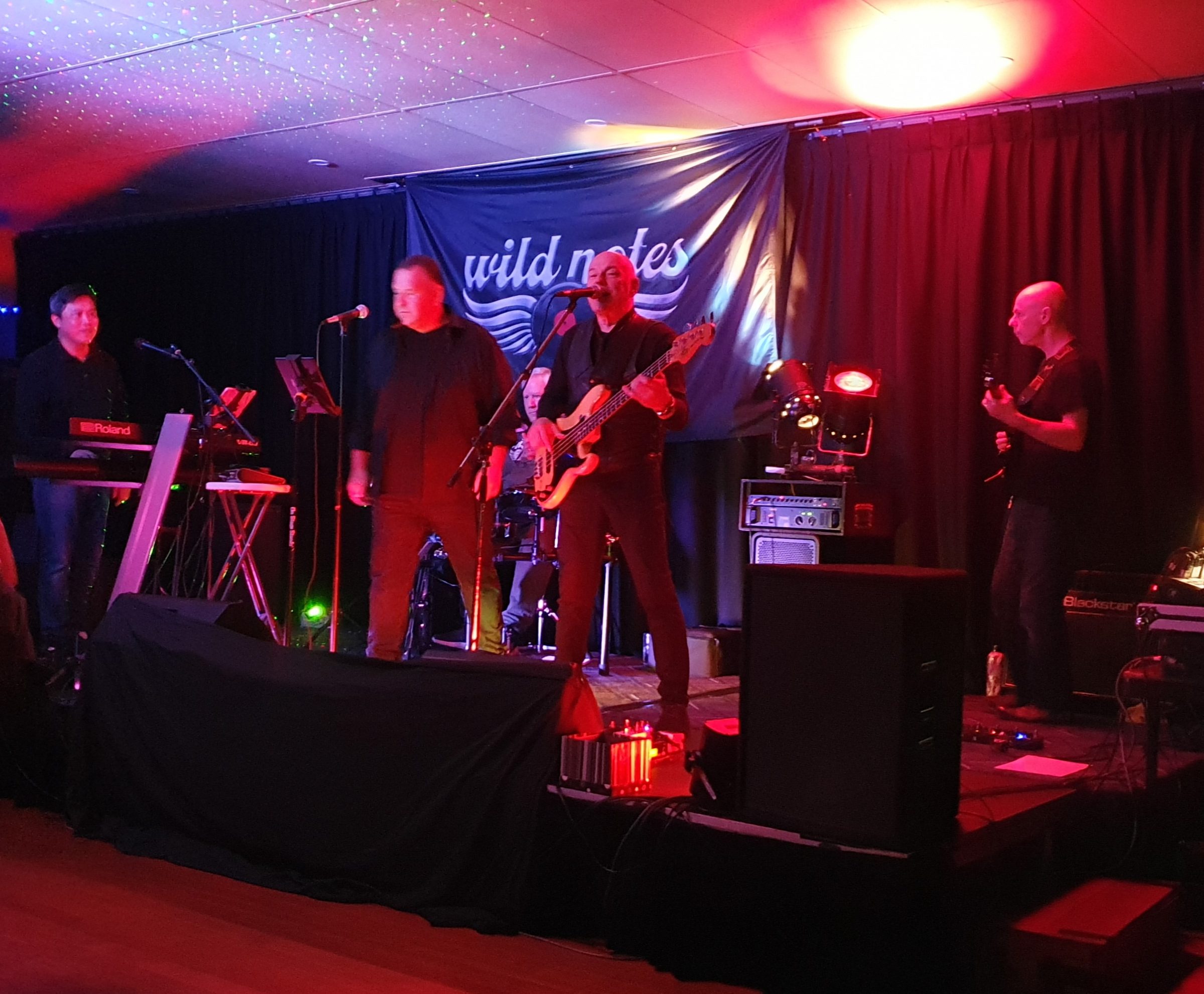 A band playing under red lights in the Wearside Bar