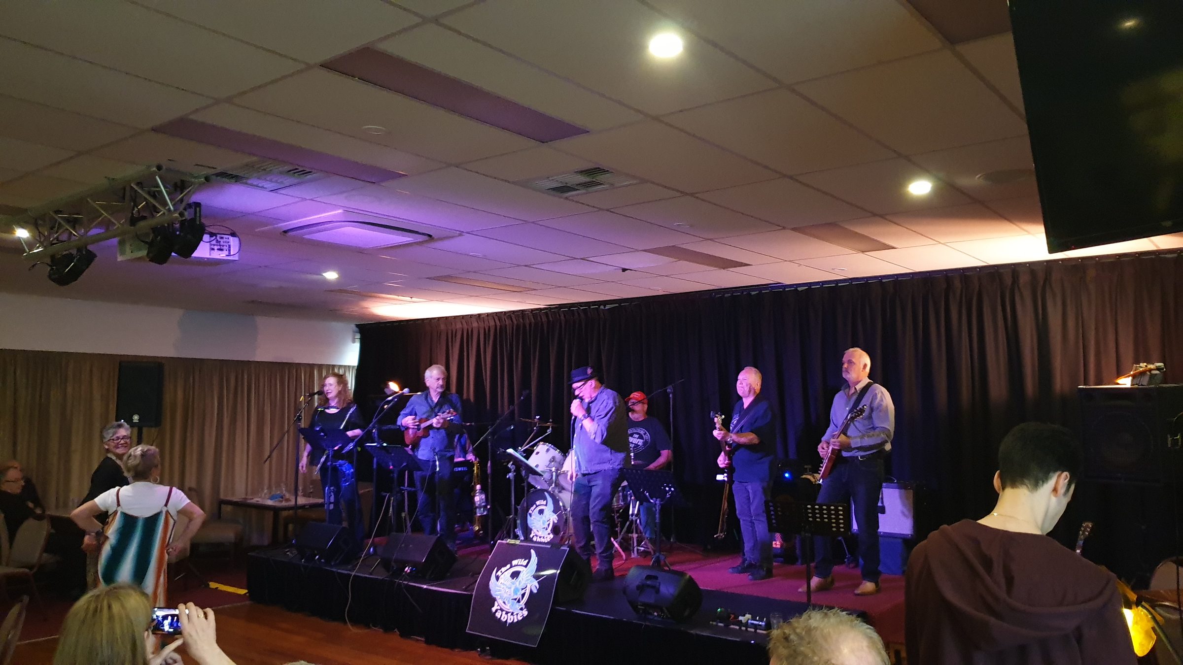 A band on stage for a packed function room